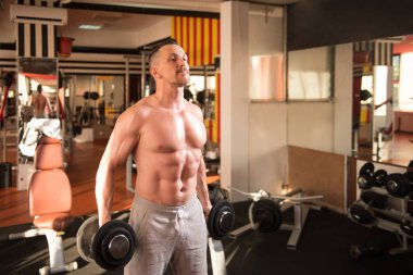 Pazı egzersiz bir spor salonunda Dumbbells ile