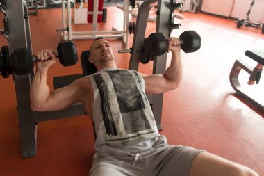 Young Healthy Man Doing Chest Exercise With Dumbbells