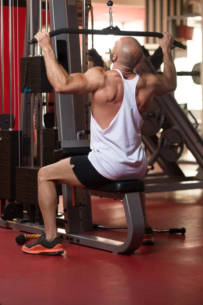 Kaslı adam arka için ağır egzersiz yaparak