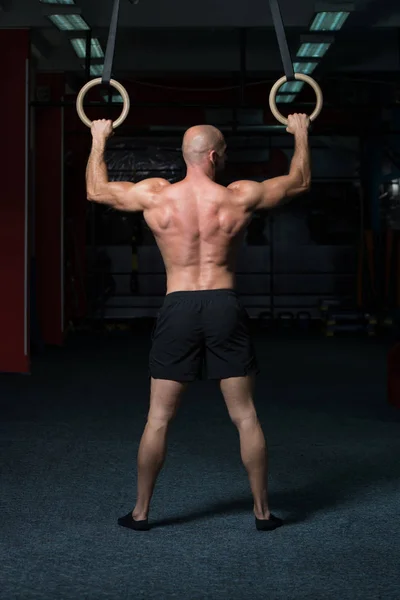 Muskulös atlet hängande på Gymnastringar — Stockfoto