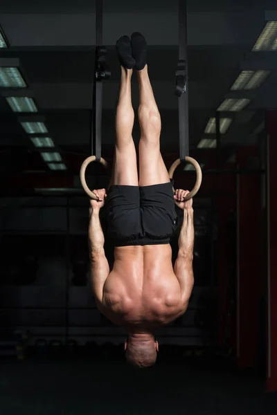 Gespierde Man houd gymnastiek ringen — Stockfoto