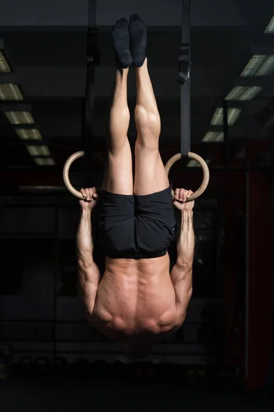 Muskulös atlet hängande på Gymnastringar — Stockfoto