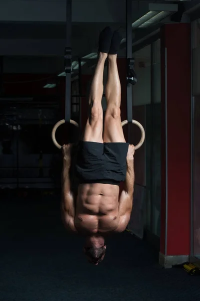 Homem muscular segurando dois anéis — Fotografia de Stock