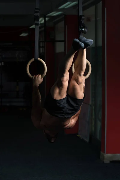 Gespierde Man houd gymnastiek ringen — Stockfoto