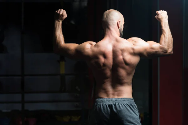 Seriöser Bodybuilder steht im Fitnessstudio — Stockfoto