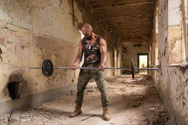 Sportowiec ćwiczeń bicepsów w ruinach — Zdjęcie stockowe