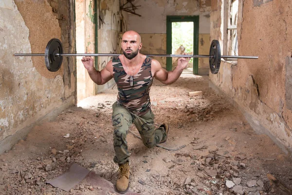 Mann mit Langhantel trainiert Beine im Schutzraum — Stockfoto