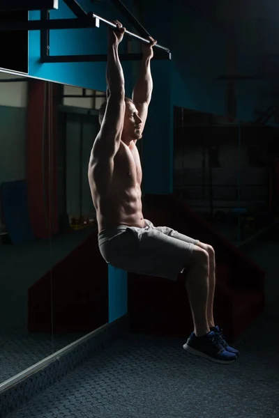 Homem realizando pendurado perna levanta exercício — Fotografia de Stock