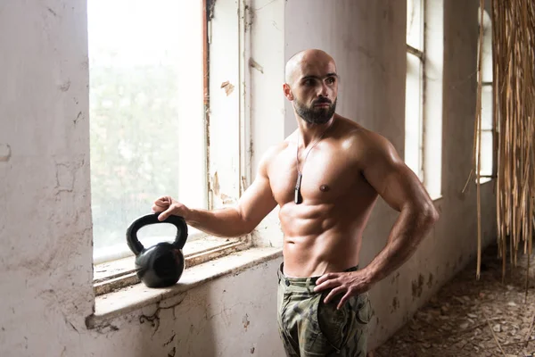 Man Exercising With Kettle Bell In Shelter — Stock Photo, Image