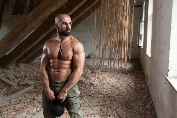 Man Exercising With Kettle Bell In Shelter — Stock Photo, Image