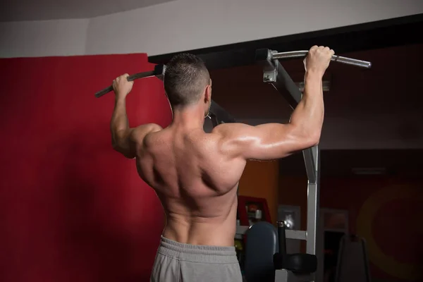 男子运动员做拉 Ups 引体向上在健身房里 — 图库照片