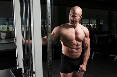 Kablo ile omuz için ağır egzersiz yaparak vücut geliştirmeci