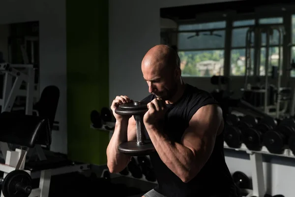 Uomo che esercita le gambe con i manubri in palestra — Foto Stock