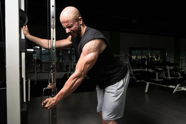 Bodybuilder doen zware oefening voor de Triceps met kabel — Stockfoto