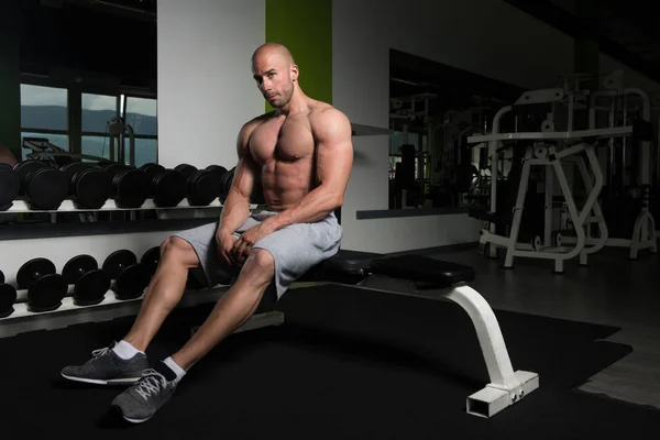 Jeune homme attrayant reposant dans la salle de gym après l'exercice — Photo