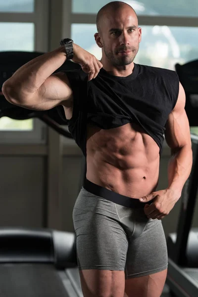 Culturista posando bíceps después de ejercicios — Foto de Stock