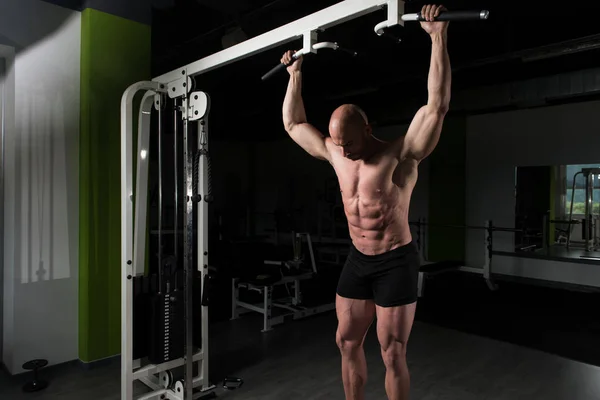 Hombre musculoso guapo flexionando músculos en el gimnasio —  Fotos de Stock