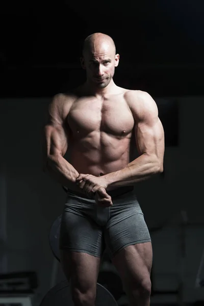 Hombre en el gimnasio mostrando su cuerpo bien entrenado —  Fotos de Stock