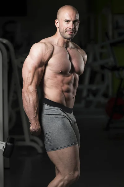 Handsome Muscular Man Flexing Muscles In Gym