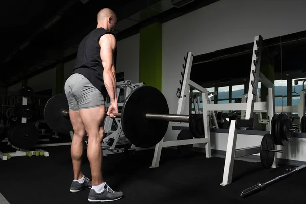 Mannen i Gym tränar tillbaka med skivstång — Stockfoto