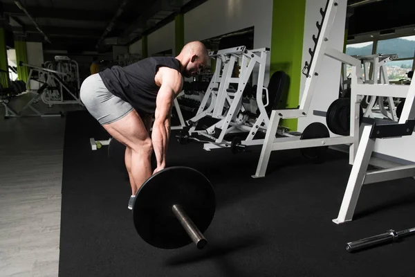 Bodybuilder uitvoeren terug trainen met Barbell In sportschool — Stockfoto