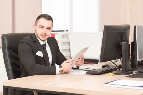 Porträt eines attraktiven Geschäftsmannes, der Zeitung im Büro liest — Stockfoto