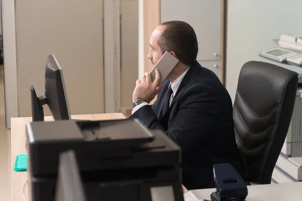Homem alegre no escritório a atender o telefone — Fotografia de Stock