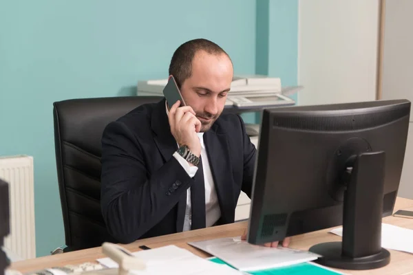 Obchodník v kanceláři mluví po telefonu — Stock fotografie