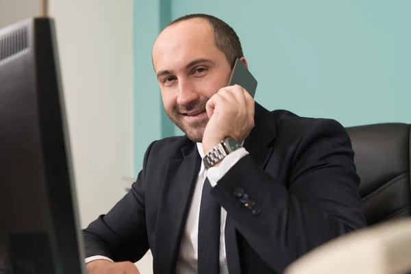 Homme d'affaires parlant au téléphone au bureau — Photo