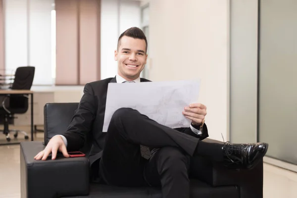 Porträt eines attraktiven Geschäftsmannes, der Zeitung im Büro liest — Stockfoto