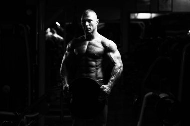 Ağırlıkları elinde tutan adam uygun