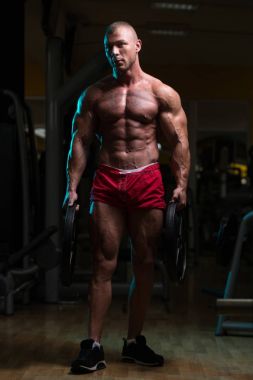 Ağırlıkları elinde tutan vücut geliştirmeci