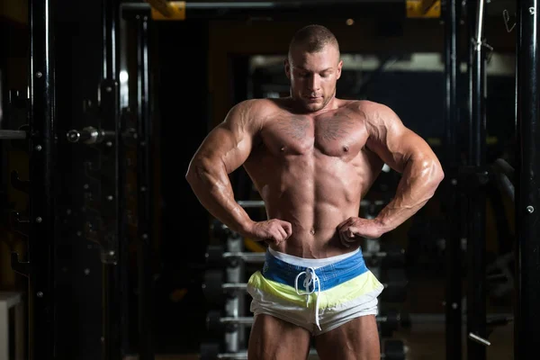 BodyBuilder sérieux debout dans la salle de gym — Photo