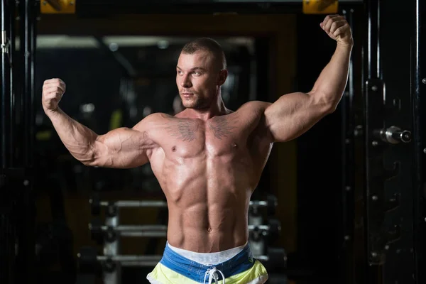 Bodybuilder posant des biceps après des exercices — Photo
