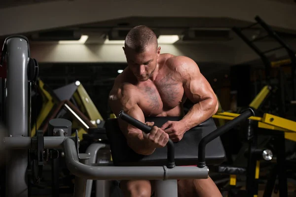 Hombre haciendo ejercicio para bíceps en la máquina de cable — Foto de Stock