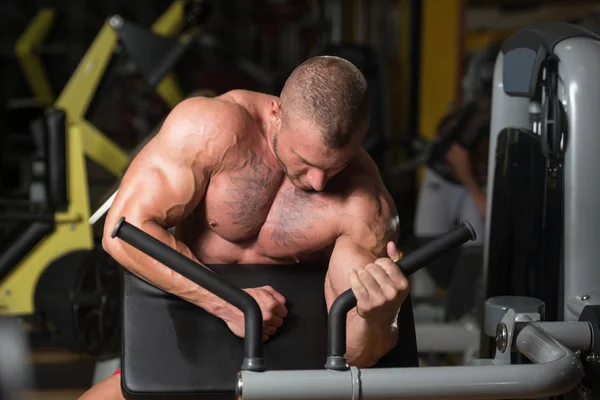 Homem fazendo exercício para bíceps na máquina de cabo — Fotografia de Stock