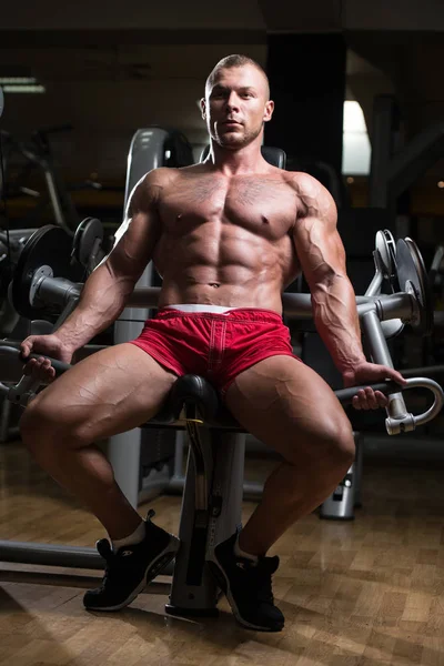 Muskularny mężczyzna wykonując Biceps na kabel maszyny — Zdjęcie stockowe
