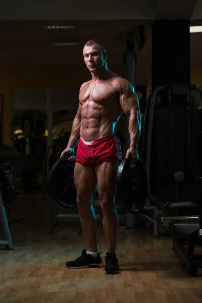 Hombre en forma sosteniendo pesas en la mano —  Fotos de Stock