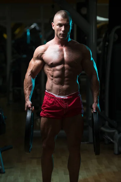 Hombre en forma sosteniendo pesas en la mano — Foto de Stock