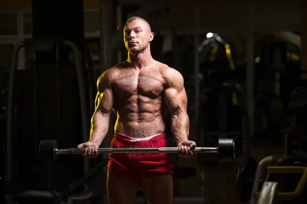 Homme dans la salle de gym faisant de l'exercice Biceps avec Barbell — Photo