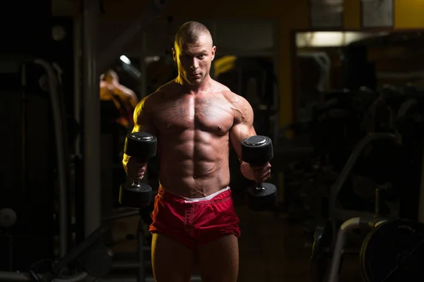 Biceps exercice avec haltères dans une salle de gym — Photo