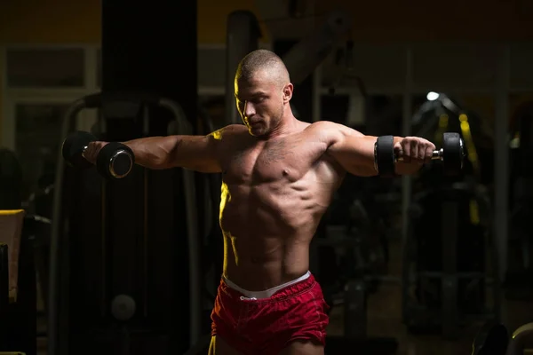 Exercice des épaules avec haltères dans une salle de gym — Photo
