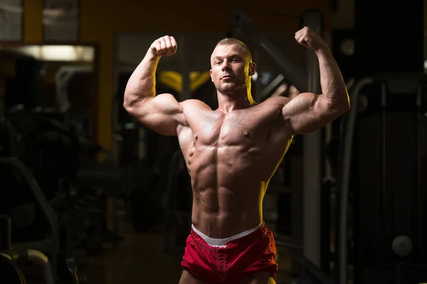 Bodybuilder poseren Biceps na oefeningen — Stockfoto