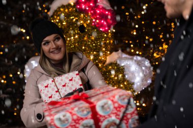 mutlu çiftimiz Noel ışıkları üzerinde hediye kutusu ile