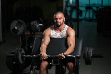Kas Adam Spor Salonunda Halterli Kollar için Ağır Ağırlık Egzersizi Yapıyor