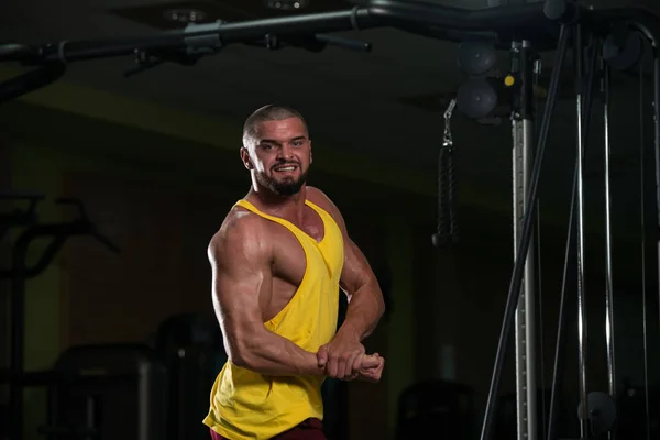 健康的青年男子站在健身房和肌肉伸缩 强运动后的肌肉运动健美健身模特 — 图库照片