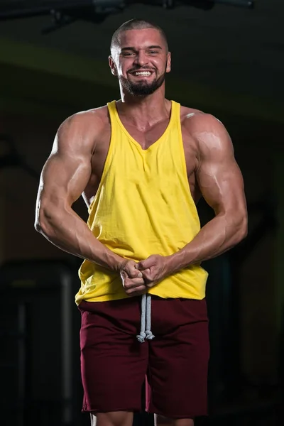 Gesunder Junger Mann Steht Stark Fitnessstudio Und Lässt Muskeln Spielen — Stockfoto