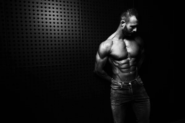 Model Flexing Muscles Near the Wall — Stock Photo, Image