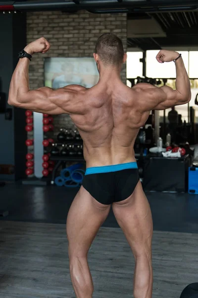 Biceps vormen van een jonge Man In sportschool — Stockfoto