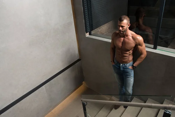 Schöner Mann lässt Muskeln auf Treppen spielen — Stockfoto